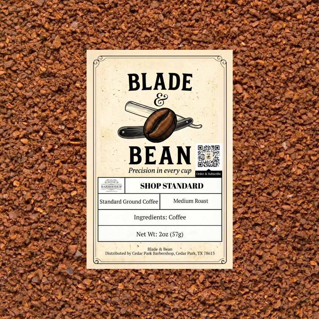 A rectangular product label for Blade & Bean coffee sits centered on a textured background of coffee grounds. The label is cream-colored with black text and an illustration of a coffee bean and scale.
