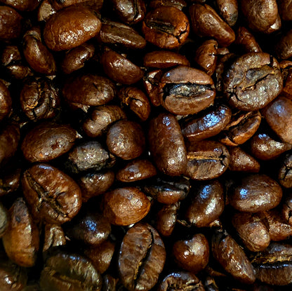 A close-up pile of glossy roasted coffee beans filling the frame.