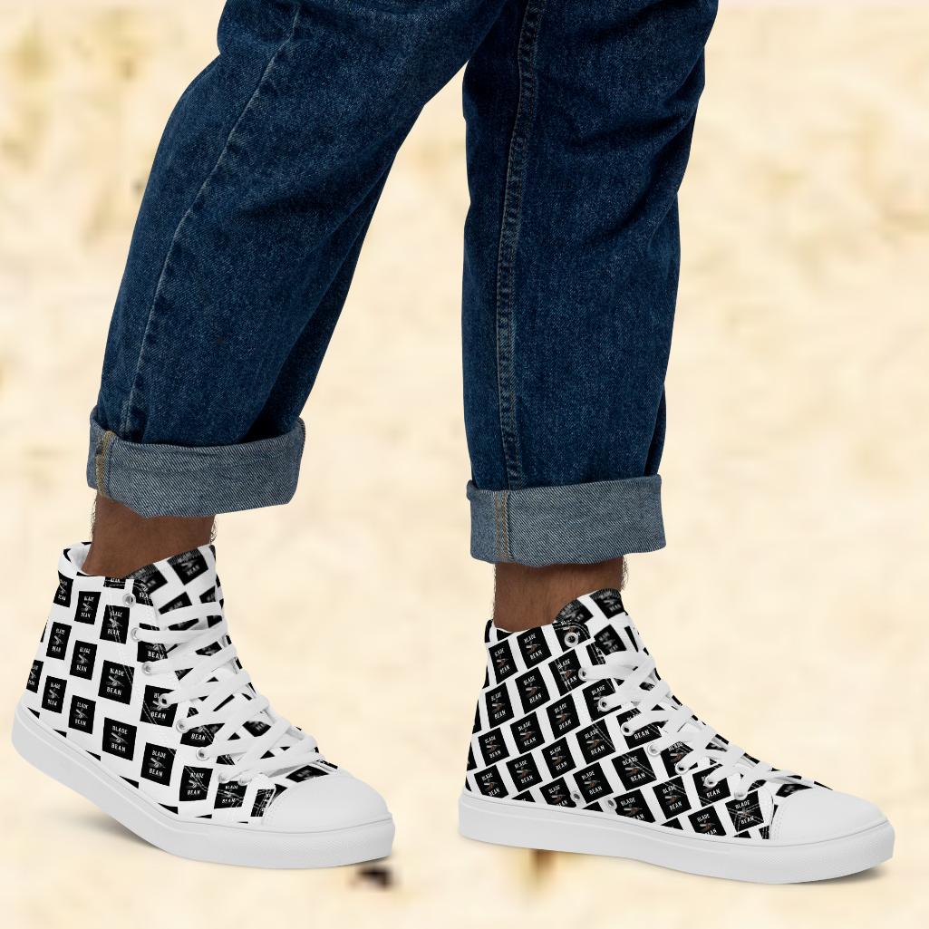 White high-top sneakers with black pattern worn with rolled-up jeans on a beige background