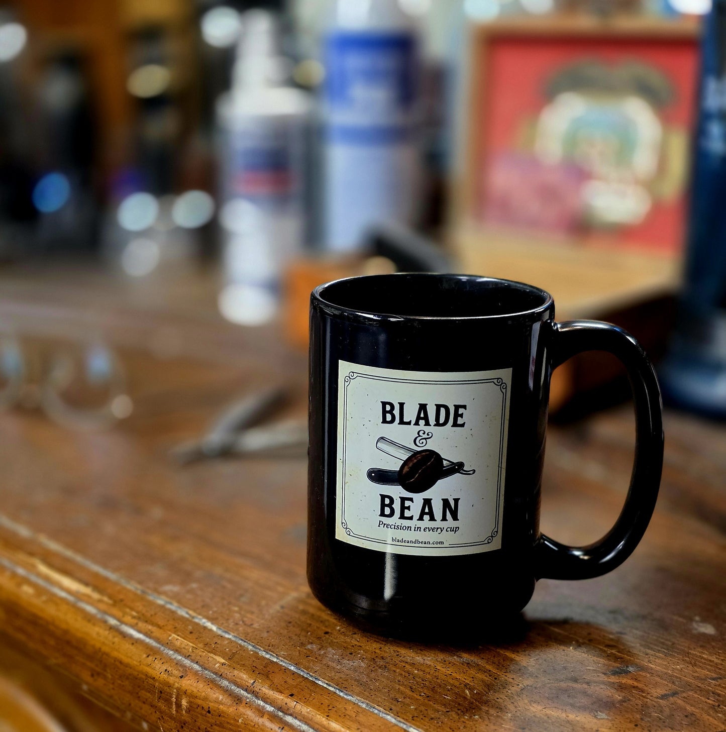 Black mug with 'Blade & Bean' label on a wooden surface