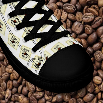 Black and white sneaker with coffee bean design on a bed of coffee beans