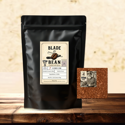 A black stand-up coffee bag labeled Blade & Bean Cashmere Coffee Roast stands on a wooden surface against a textured beige wall, with a small square brown coffee bean sample pack placed beside it.
