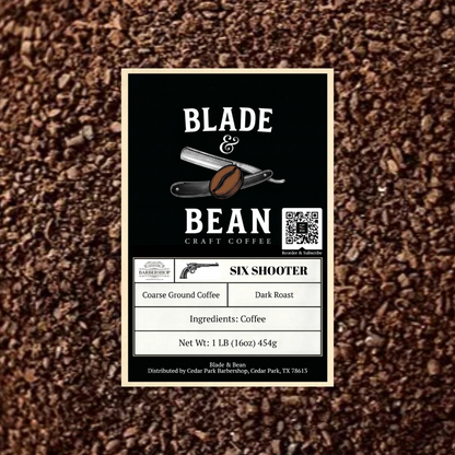 A coffee label for Blade & Bean Craft Coffee's 'Six Shooter' dark roast coffee, shown against a textured background of coffee beans. The label features a black background with white text and illustrations of a coffee bean and a revolver.
