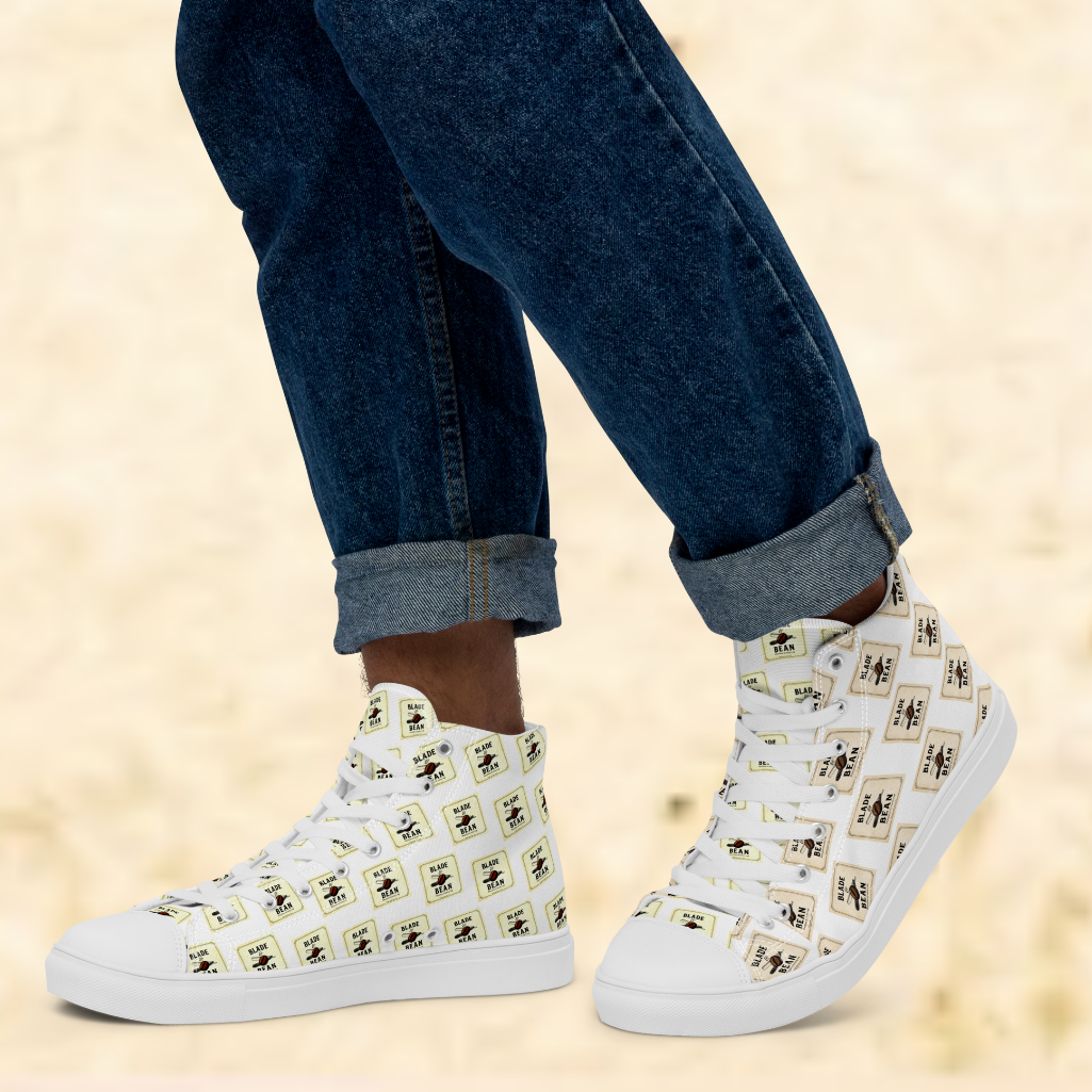 White high-top sneakers with black and yellow pattern worn with rolled-up jeans on a beige background
