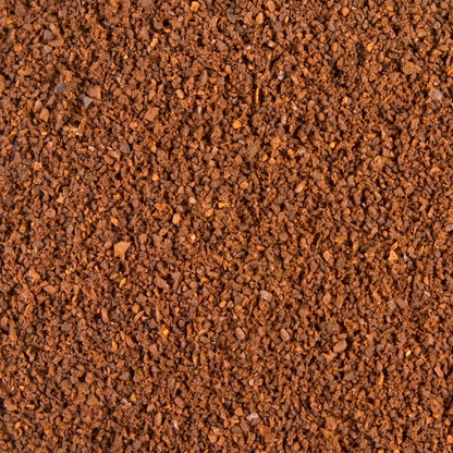 A close-up texture shot of finely ground brown coffee beans or coffee powder, filling the entire frame.