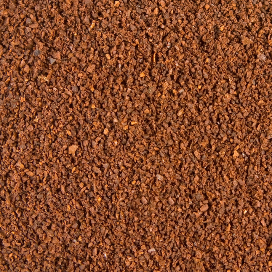 A close-up texture shot of finely ground brown coffee beans or coffee powder, filling the entire frame.