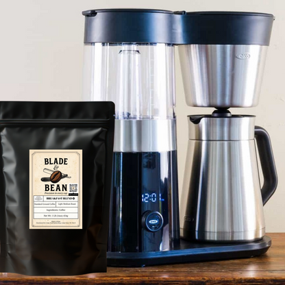 Coffee maker with a bag of Blade & Bean coffee on a wooden surface