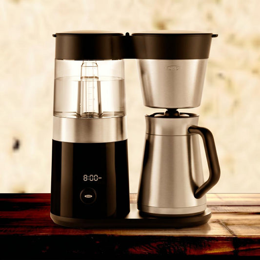 Coffee maker with digital display on a wooden surface