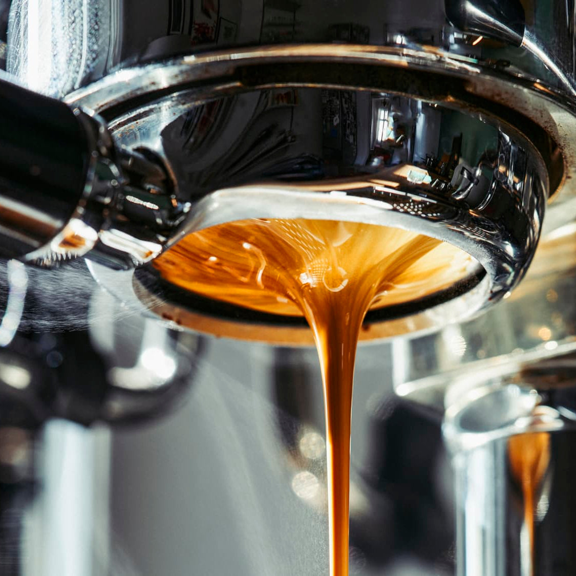 Espresso being poured from a machine into a cup.