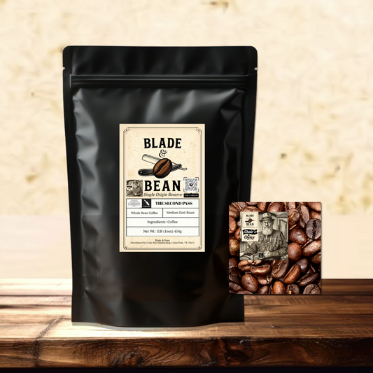 A black stand-up coffee bag labeled Blade & Bean The coffee sits on a wooden surface with a small square coffee bean graphic card beside it against a textured beige wall.