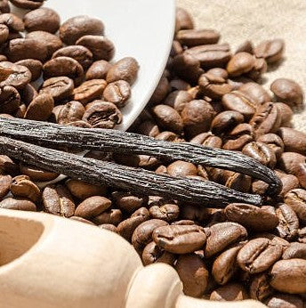 Close-up of coffee beans with a vanilla bean on top