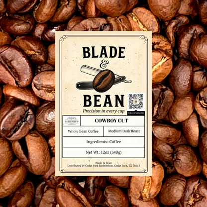 A coffee label for Blade & Bean 'Cowboy Cut' whole bean coffee, centered over a background of roasted coffee beans. The label is cream-colored with black text and an illustration of a coffee bean and blade.