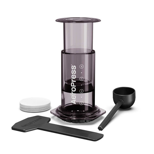 AeroPress coffee maker with components on a white background