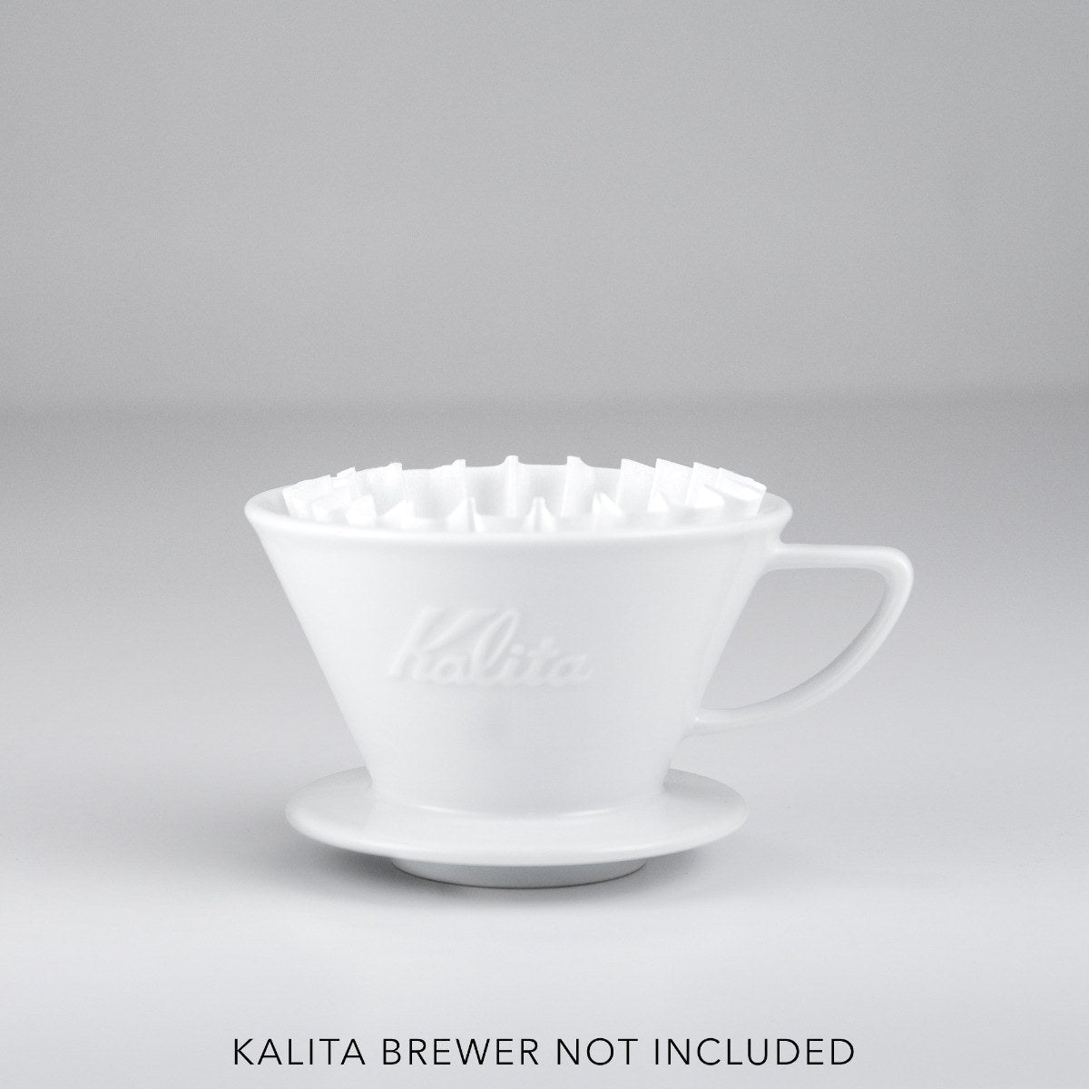White Kalita coffee filter on a gray background with 'Kalita Brewer Not Included' text.